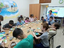 Майстер-клас із малювання: діти наживо в залі створюють малюнки, доки інші учасники табору повторюють процес онлайн.
