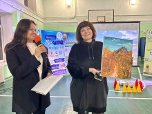 Керівник гуртка Наталя Шмакова тримає у руках картину, яку написала власноруч: "Терикони - вартові Донеччини"