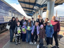 Група дітей разом з керівниками біля потяга на залізничному вокзалі