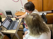 Представники військової адміністрації сидять за столом та слухають доповідача на семінарі