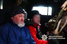 Чоловік та хлопчик у бронежилеті в евакуаційному автомобілі