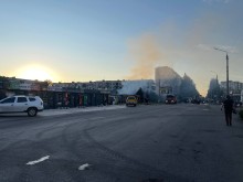 Крамниці та автомобілі поруч зі зруйнованим супермаркетом.
