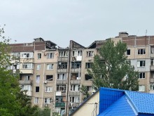 Багатоповерхова будівля з пошкодженою покрівлею, яку зруйнував ворог.