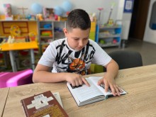 У створеному читальному просторі «Бібліоколо» у Центрі підтримки ВПО Краматорського району «МиРазом» у Полтаві хлопчик читає книгу.