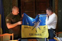 Керівники громад тримають військовий прапор