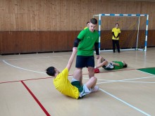 Дія у спортивному залі.
Гра у футбол. Один з футболістів допомогає піднятись з підлоги іншому.