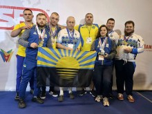 Команда українських спортсменів тримає медалі та прапор Донеччини