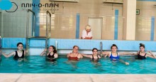 Дівчата у басейні з блакитною водою, позаду жінка-лікар