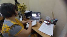 Представник військової адміністрації сидить за столом та слухає доповідача на семінарі