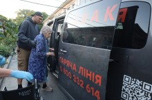 Жінку старшого віку саджають у евакомобіль