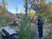 Правоохоронець стоїть біля зруйнованого ворожим обстрілом будинку