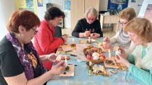 Жінки – переселенки на майстер - класі розмальовують писанки до Великодня, проявляють креативність та зацікавленість, отримуючи задоволення від роботи