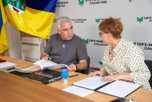 Володимир Проскунін обговорює з Надією Девіцькою подальшу співпрацю та допомогу між громадами. На столі лежить книга про Донеччину.