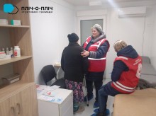 Фахівчиня Червоного Хреста проводить медичний огляд жінки похилого віку
