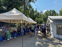 На вулиці розгорнуті намети. Люди стоять у черзі для отримання консультацій