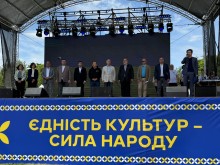 Учасники фестивалю на сцені з написом "Єдність культур - сила народу"