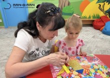 Вихователь допомагає дитині на майстер-класі