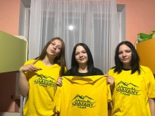 Троє дівчат хизуються новими футболками з логотипом табору