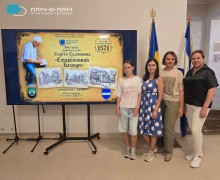 Група людей фотографується біля банера виставки