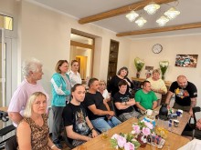 Пацієнти центру з членами робочої групи у приміщенні центру за столом