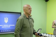 Вадим Філашкін тримає в руці нагрудний знак, призначений для нагородження енергетиків.