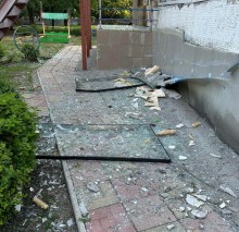 Вибиті вікна лежать на землі після обстрілу окупантів