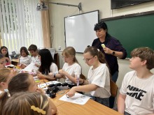 Діти сидять за партами та зосереджено працюють із 3D-ручками, створюючи об'ємні фігури за трафаретами