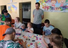 Діти за столом під наглядом психолога та педагога займаються вправами на стресостійкість, виготовляють аплікації