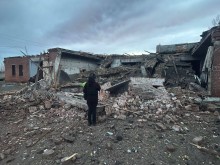 Правоохоронець стоїть біля будинку, який зруйнували окупанти