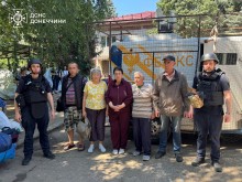 Рятувальники групи "Фенікс" та група дружківчан, які погодились на евакуацію, стоять біля евакомобіля