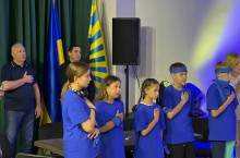 Юні учасники фестивалю тримають руку на серці під час виконання Гімну