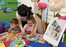 Вихователь допомагає дитині на майстер-класі