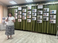 Представниця Селидівської  громади виступає з промовою на фоні експозиції фотовиставки.