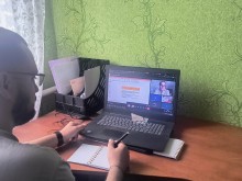 Представник військової адміністрації сидить за столом та слухає доповідача на семінарі