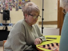 Жінка похилого віку грає в шашки