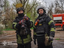 Двоє рятувальників, один з них тримає пожежний кран.