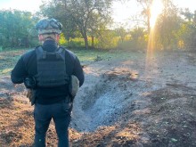 Правоохоронець стоїть біля вирви від російського снаряду