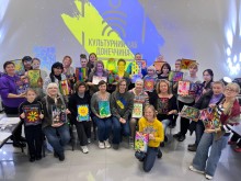 Дорослі відвідувачі хабу на груповому фото з картнами в рамках, які намальовані на арттерапії