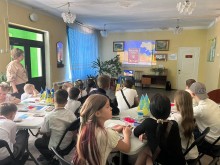 Діти сидять за столами та переглядають на екрані відеоролик про Конституцію України