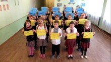 Група школярів у вишиванках, тримають жовті та сині плакати зі словами «Гідність», «Свобода», «Вірність»