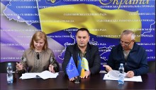 Підписання меморандуму. Голови громад та народний депутат сидять за столом.