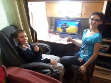 Діти, переможці конкурсу, переглядають відеороботу. На моніторі синьо-жовта обкладинка відеоролику "Інтерв'ю з героєм"