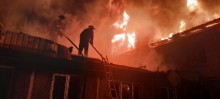 Рятувальники гасять пожежу на покрівлі постраждалого від атаки окупантів будинку.