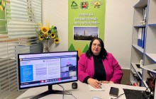 Представник військової адміністрації сидить за столом та слухає доповідача на семінарі