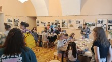 Група дітей та дорослих на майстер-класі в залі з виставковими стендами