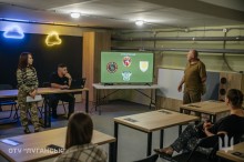 Військові проводять презентацію для молоді в межах проєкту «Наша Донеччина. Наш дім. Наша фортеця». На екрані — емблеми бойових підрозділів.