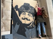 Художниця вішає портрет героя України на вікні школи мистецтв у Франції
