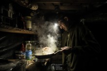 Дія у бліндажі, військовий тримає пательню, поруч олія на голові ліхтарик.