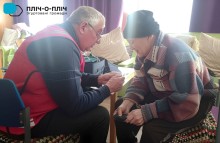 Представник Червоного Хреста веде медичний прийом жінки похилого віку