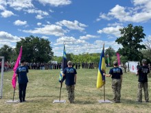 Джури стоять біля прапорів на фоні учасників вишколу "Січ незламних